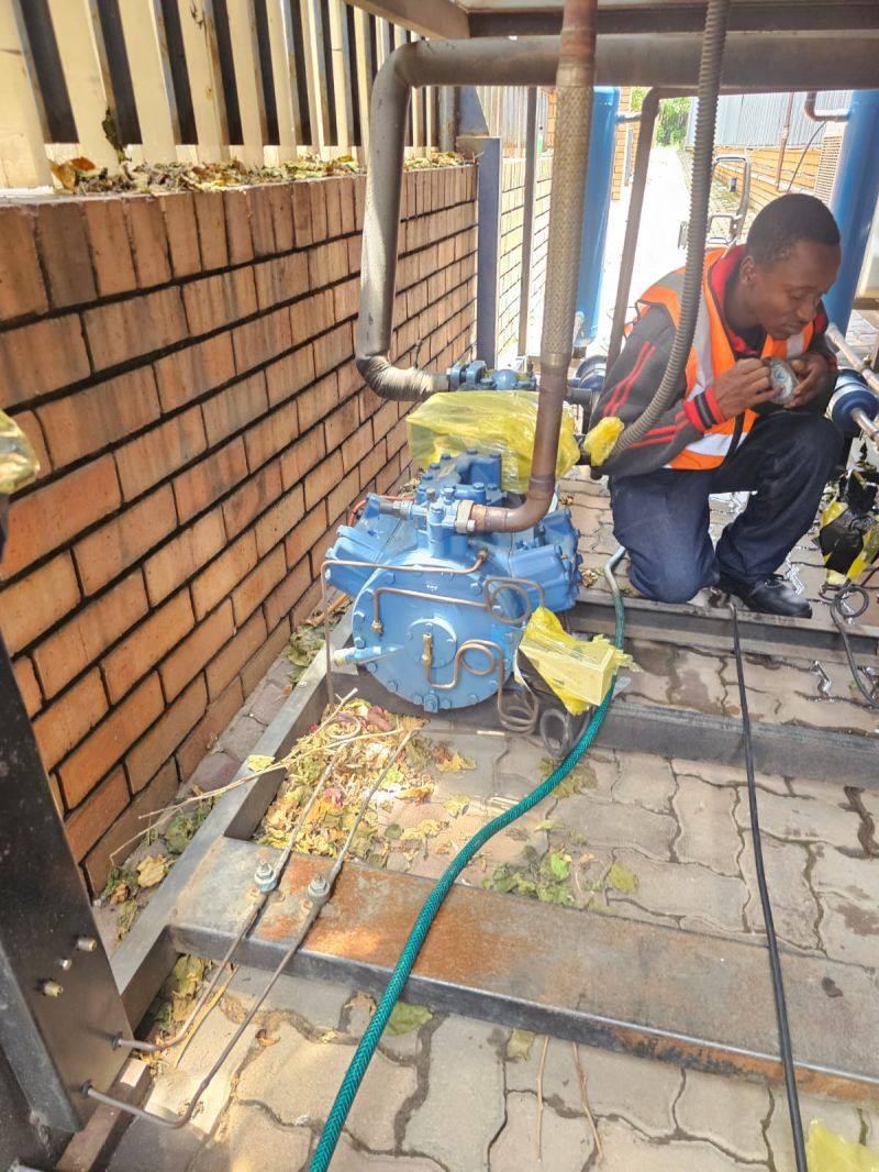 Technician servicing an outdoor temperature drop unit