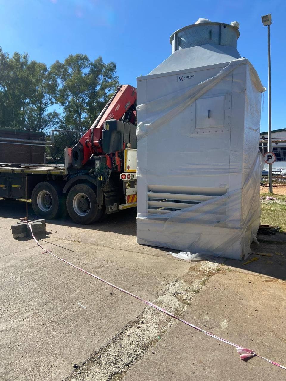 Crane truck delivering a cooling tower unit to an industrial site